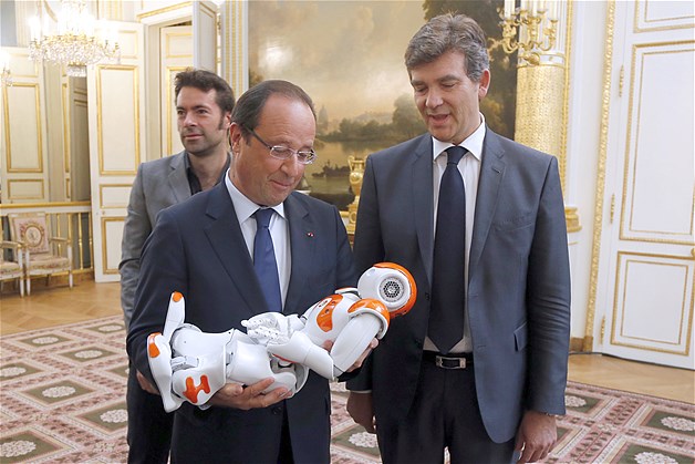 François Hollande porte un robot Nao comme si c’était un bébé.